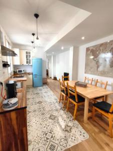 uma cozinha e sala de jantar com uma mesa e um frigorífico azul em Tirwal Suite em Teruel