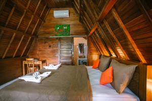 ein Schlafzimmer mit einem großen Bett in einem Holzzimmer in der Unterkunft JUN COTTAGE in Toyapakeh