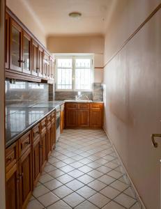 a kitchen with wooden cabinets and a tiled floor at Hadrians Den in Heart of Plaka by JJ Hospitality in Athens