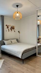 a bed in a bedroom with a mirror and lights at Studio apartment in Pärnu