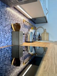 a kitchen with blue tiles on the wall at Studio apartment in Pärnu