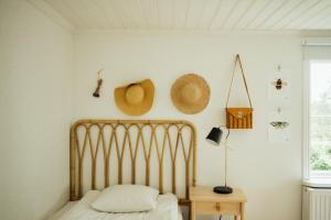 a bedroom with a bed and straw hats on the wall at Lindeborgs Eco Retreat in Vrena