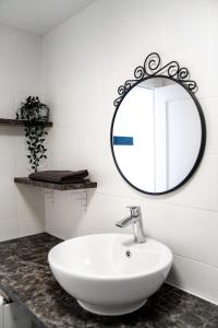 a bathroom with a white sink and a mirror at New & Renovated Vacation Apartment in Costa de Antigua