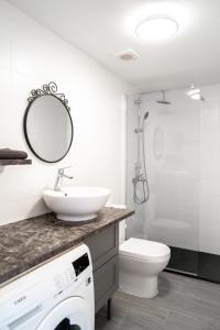 a bathroom with a sink and a toilet and a mirror at New & Renovated Vacation Apartment in Costa de Antigua