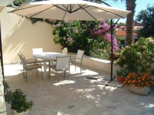 a table and chairs under an umbrella on a patio at Apartments Tomic in Premantura