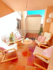 Habitación con sillas, mesa y balcón. en Tirwal Suite Judería, en Teruel