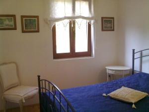 a bedroom with a bed and a chair and a window at Apartments Tomic in Premantura