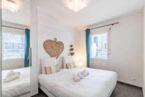 sypialnia z dużym białym łóżkiem z sercem na ścianie w obiekcie Beautiful apartment with balcony - Center Cannes w Cannes