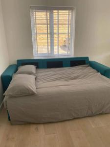 a large bed with a blue headboard in a bedroom at Spacious and Cosy 2 Bedroom Flat in Bermondsey in London