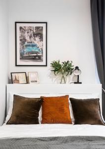 a bedroom with a white bed with an orange pillow at Żoliborz Elite Apartment in Warsaw