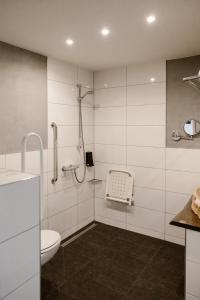 a white bathroom with a shower and a toilet at Hotel Torpedoloods in Hoek van Holland