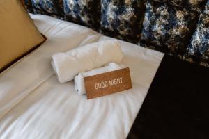 a bed with towels and a sign that reads good night at Mijn Torpedoloods in Hoek van Holland
