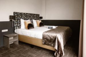 a bedroom with a large bed with a headboard at Hotel Torpedoloods in Hoek van Holland