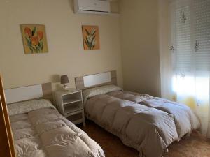 um quarto com 2 camas e uma mesa com um espelho em Apartamento Sanchiz em Monóvar