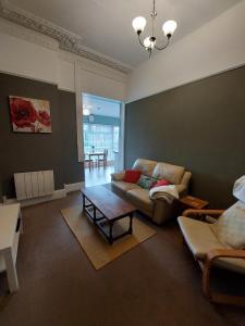 a living room with a couch and a table at Abbey View Holiday Flats in Torquay +31 photos