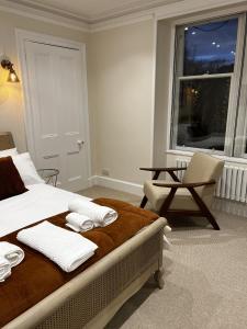 a bedroom with a bed with towels and a window at St Duthus Villa Guesthouse in Tain