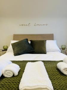 a large bed with two white towels on it at St Duthus Villa Guesthouse in Tain
