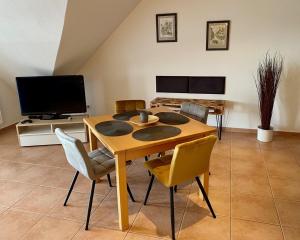 a dining room with a table and chairs and a television at Ferienwohnungen Dehn in Bad Dürkheim