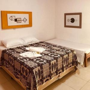 Un dormitorio con una cama con una manta. en Pousada Vida Mar en Barra Grande