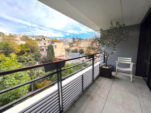 een balkon met een stoel en uitzicht op de stad bij STUDIO avec terrasse 400m Croisette / Rue d’Antibes in Cannes