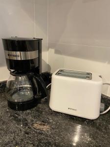 a coffee maker and a toaster sitting on a counter at Departamento para 2 personas in Rosario