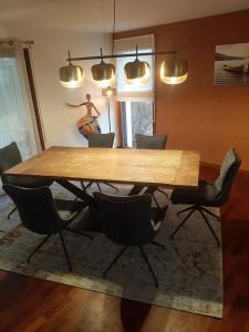 comedor con mesa de madera y sillas en ESMAEL, en Larmor-Baden
