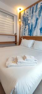 a white bed with two towels on top of it at B&B Giro Di Boa in Lampedusa