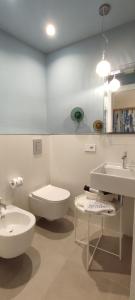 a white bathroom with a toilet and a sink at B&B Giro Di Boa in Lampedusa
