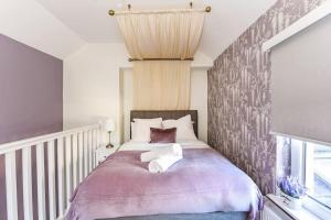 a bedroom with a large bed with a purple blanket at Modern Two-Level Apartment in Pontcanna in Cardiff