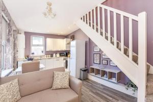 a living room with a couch and a staircase at Modern Two-Level Apartment in Pontcanna in Cardiff