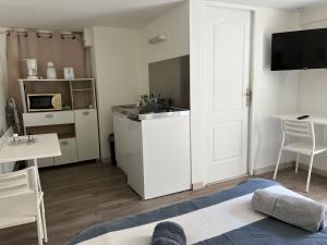 um quarto branco com uma cozinha e uma porta branca em Studio calme et indépendant proche Tours em Fondettes