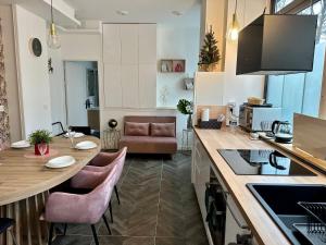 Logement GUÉNOT pour 5 personnes sur Paris 11 في باريس: مطبخ وغرفة معيشة مع طاولة وكراسي