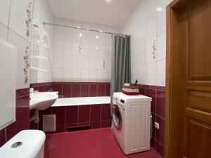 a bathroom with a washing machine and a sink at Чарівна, простора квартира в 2хв від МВЦ, Лівобережна in Kyiv
