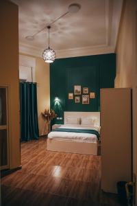 1 dormitorio con cama y pared verde en Hathor House, en El Cairo