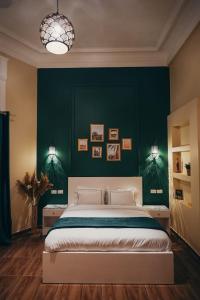 a bedroom with a large bed with a green wall at Hathor House in Cairo