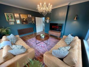 a living room with two couches and a chandelier at West Hendford House - Apt 1 in Yeovil