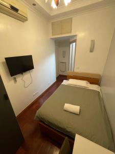 Schlafzimmer mit einem Bett und einem Flachbild-TV in der Unterkunft KayDee GuestHouse in Rom