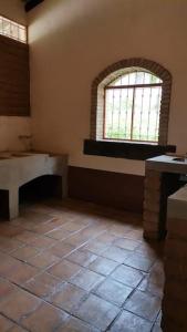 Santa María TecomavacaにあるCasa Rustica en la Reserva Tehuacán-Cuicatlánのタイルフロアの客室で、大きな窓が付いています。