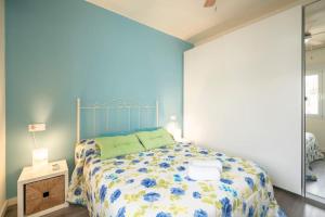 a bedroom with a bed with a blue wall at Casa Pablo -Granada- in Granada