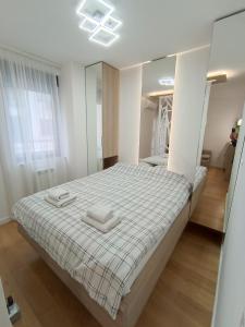 a bedroom with a bed with two towels on it at Galija apartment in Belgrade