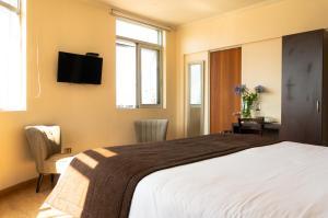 Una cama o camas en una habitación de Hotel Plaza Cienfuegos