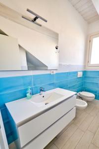uma casa de banho com um lavatório branco e um WC. em Affittimoderni Isola Rossa Borgo - IRGI11 em Isola Rossa