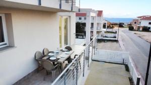 - Balcón con mesa y sillas en un edificio en Affittimoderni Isola Rossa Borgo - IRMI06 en Isola Rossa