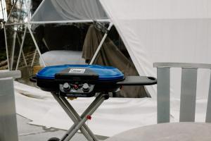 a blue grill on a table in front of a tent at Les diamants de l'éternel in Saint-David-de-Falardeau