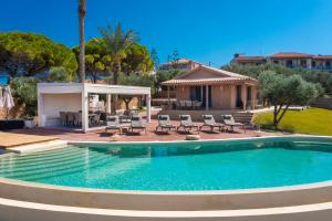 basen z krzesłami i dom w obiekcie Villa Carvella - A Sublimely Relaxing Escape! w mieście Tsilivi