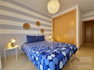 Un dormitorio con una cama azul y blanca y una mesa en Casa dos Peixinhos T1 by YHA, en Conceição