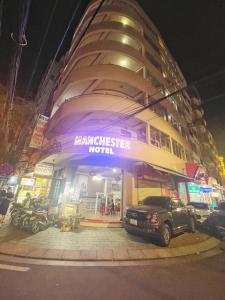 a building with a car parked in front of it at Anh Minh - Manchester Hotel Tran Phu Beach Nha Trang in Nha Trang