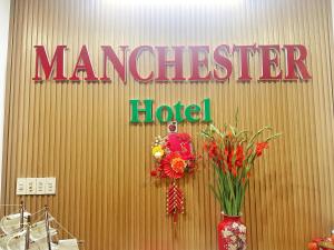 a sign on a wall with flowers in a vase at Anh Minh - Manchester Hotel Tran Phu Beach Nha Trang in Nha Trang