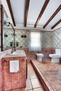 ein Bad mit einem Waschbecken, einem WC und einem Fenster in der Unterkunft Vivienda Vacacional Finca Aradri in Tinguatón