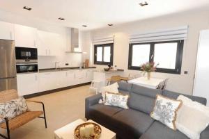 salon z niebieską kanapą i kuchnią w obiekcie Estupendo Piso Nuevo en Playa Victoria w Kadyksie